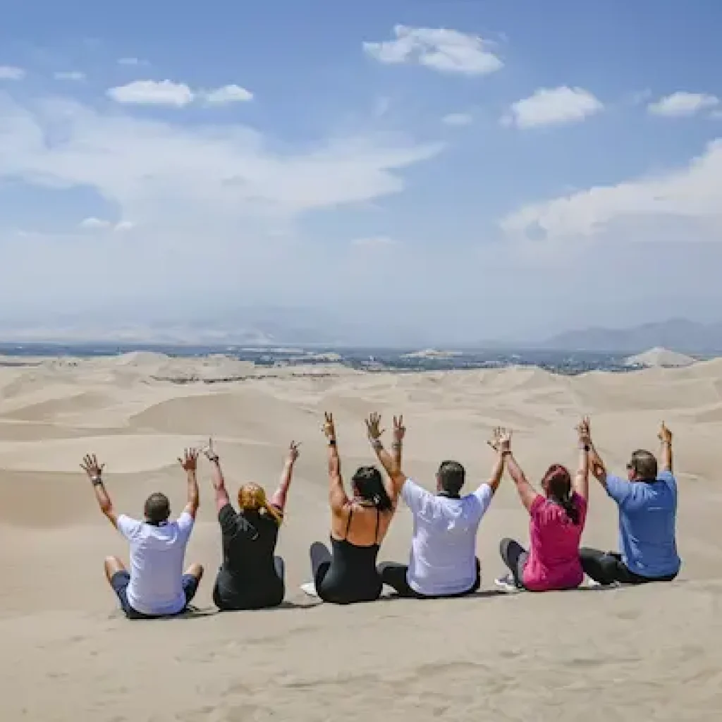 personas en el desierto disfrutando de los descuentos por grupos en tours a Ica